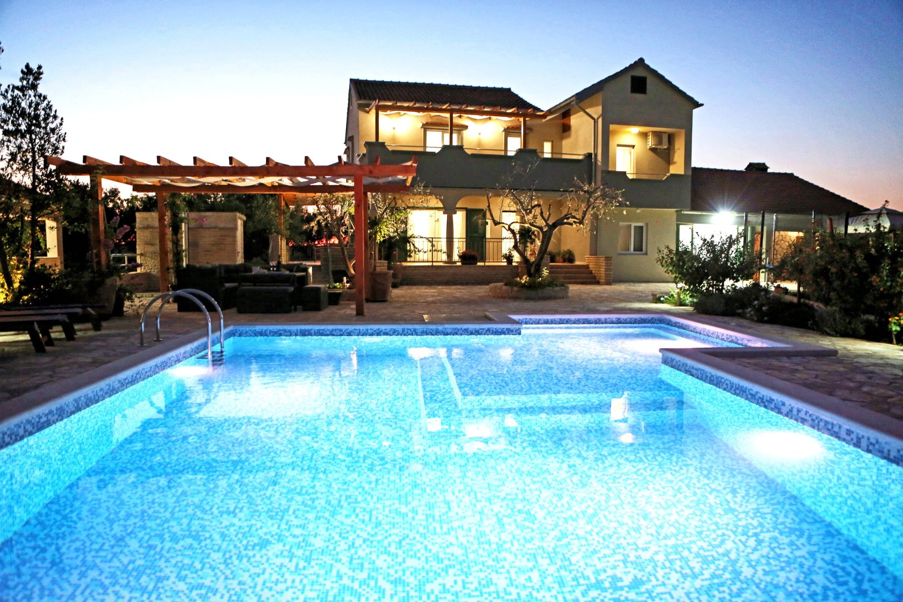Die Villa und der Pool in der Dämmerung